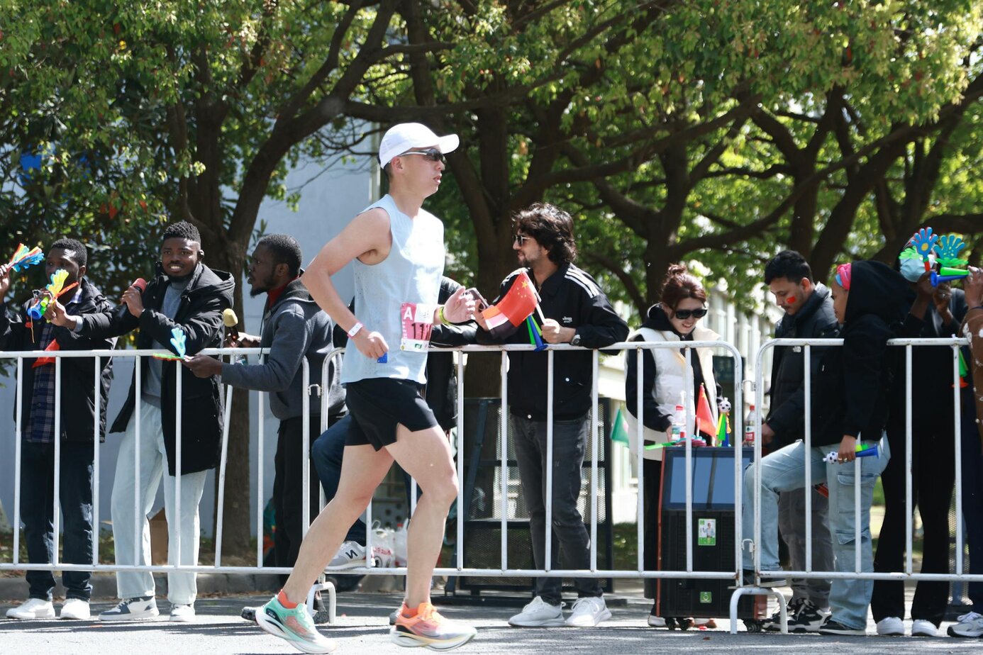 a marathon runner passes a cheering crowd