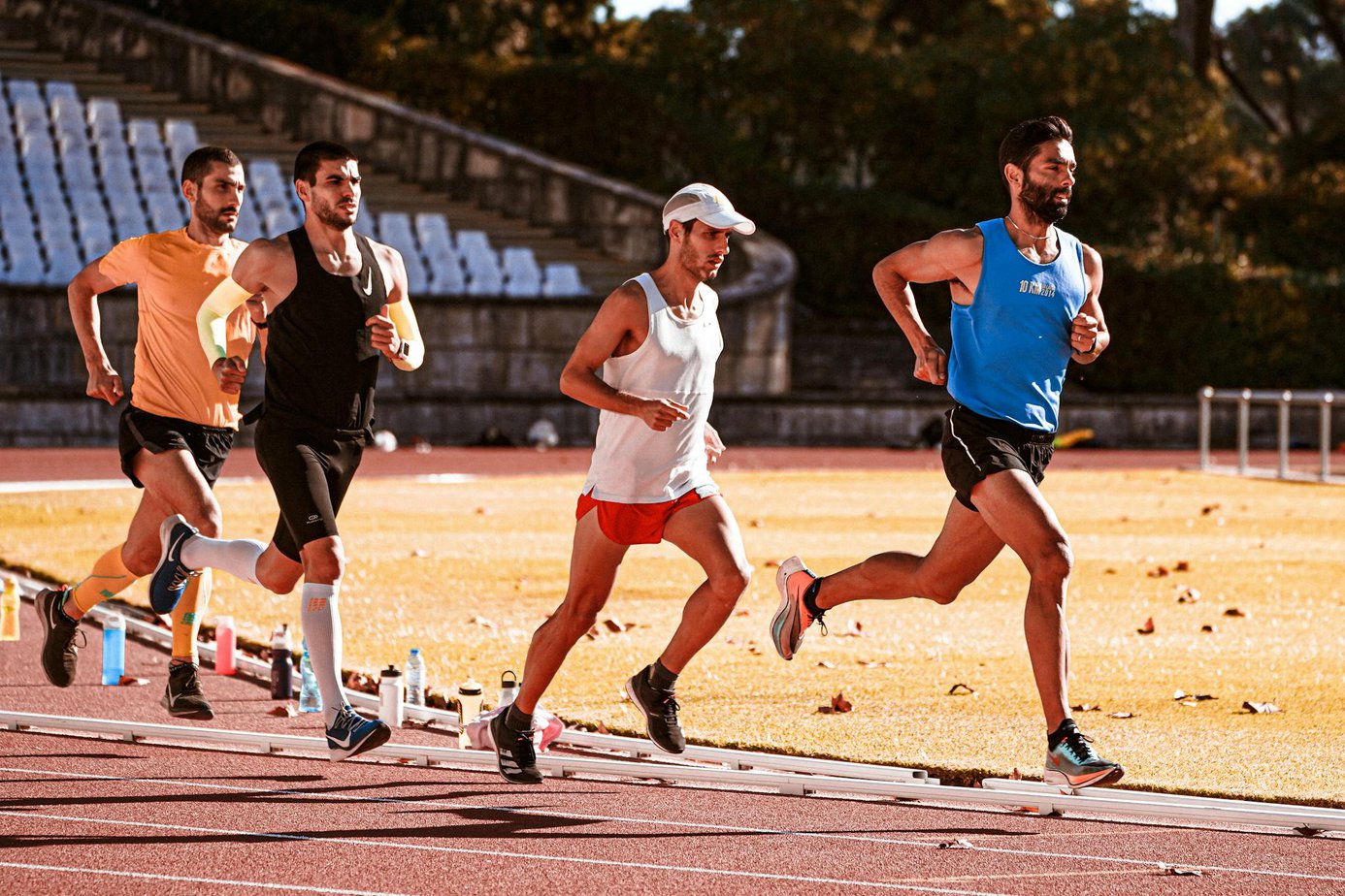 four men running on a sunny outdoor